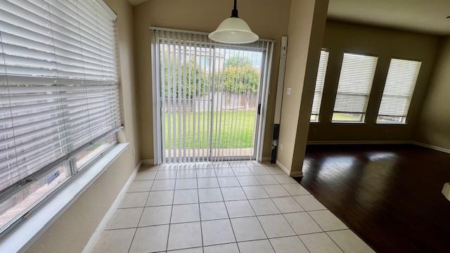 entryway featuring baseboards and light tile patterned floors