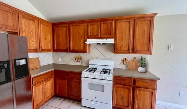 1616 Bowerton Dr, Austin, TX 78754 - kitchen with white range with gas stovetop, under cabinet range hood, fridge with ice dispenser, backsplash, and brown cabinets