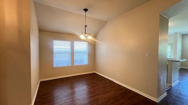1616 Bowerton Dr, Austin, TX 78754 - unfurnished dining area with dark wood-style flooring, lofted ceiling, and a chandelier