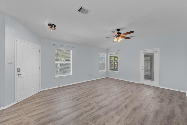 unfurnished room featuring visible vents, a wealth of natural light, and wood finished floors