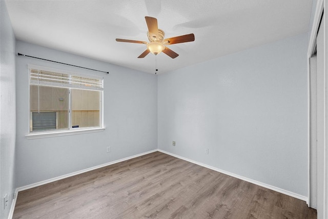 unfurnished room featuring baseboards, a ceiling fan, and wood finished floors