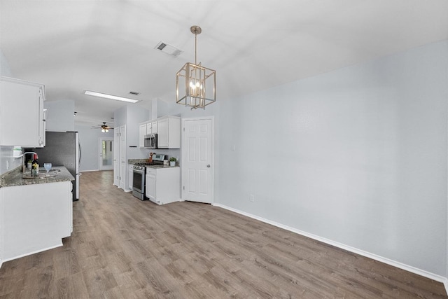 kitchen with baseboards, stainless steel appliances, wood finished floors, and visible vents