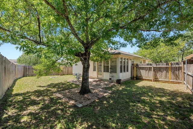 view of yard with a fenced backyard and a sunroom