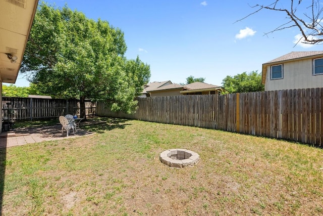view of yard featuring a fire pit, a fenced backyard, and a patio area