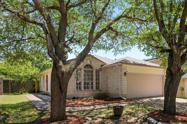 ranch-style home featuring a garage, fence, and concrete driveway