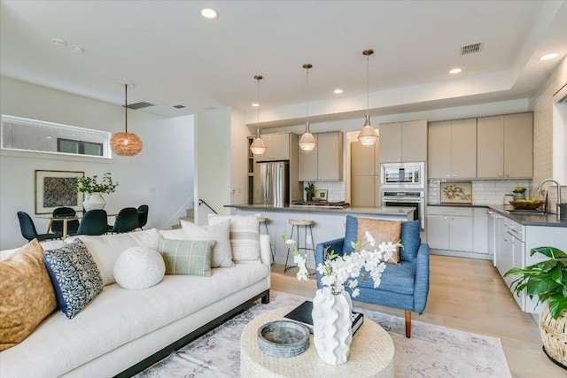 living room with visible vents, recessed lighting, and light wood finished floors