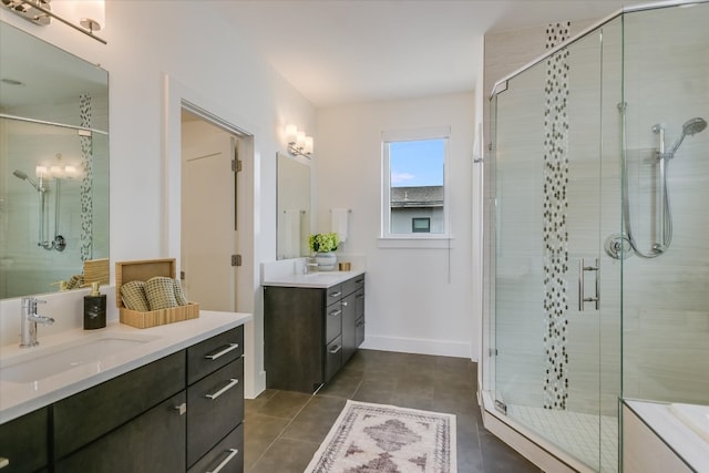 bathroom featuring a sink, tile patterned flooring, baseboards, two vanities, and a stall shower