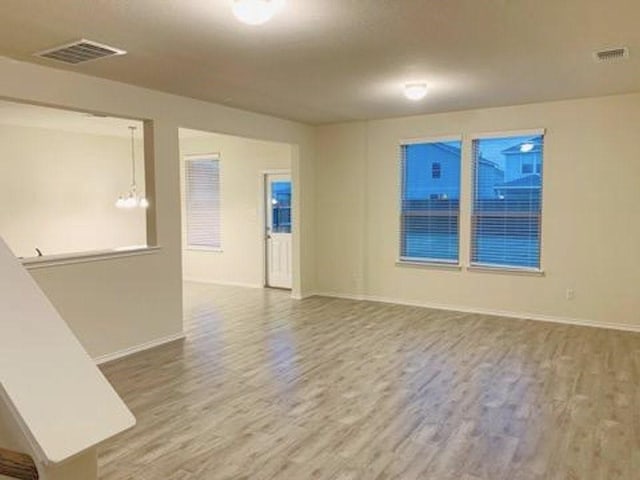 spare room with wood finished floors and baseboards