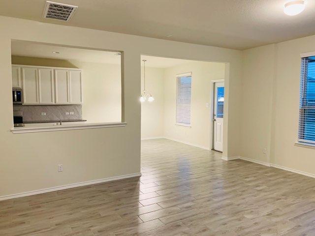 unfurnished living room featuring wood finished floors and baseboards