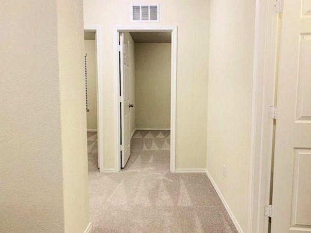 hallway featuring carpet flooring and baseboards