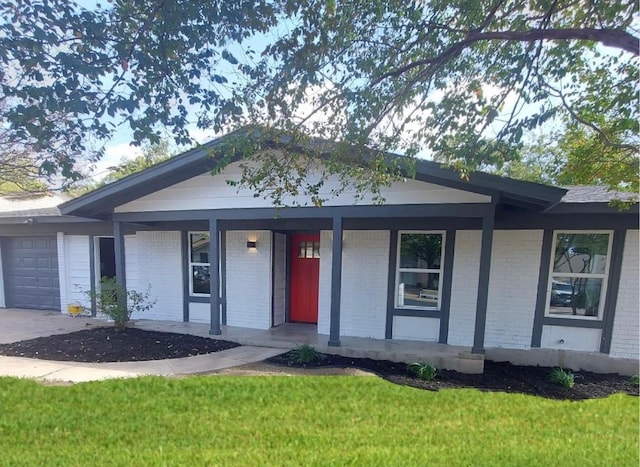 ranch-style home with brick siding, an attached garage, covered porch, and a front yard