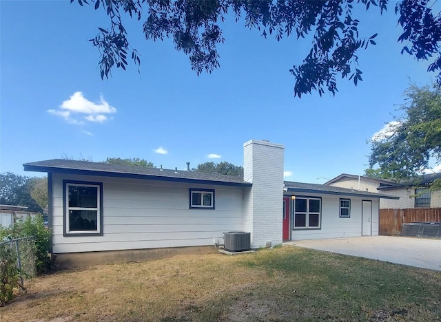 rear view of property with a patio, central AC, fence, and a chimney