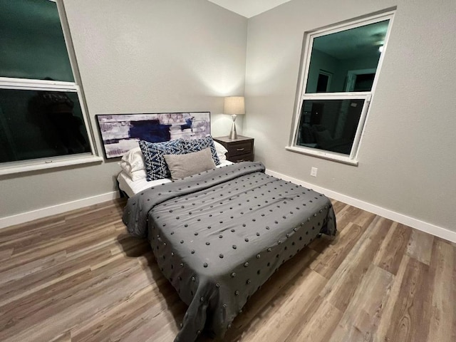 bedroom featuring baseboards and wood finished floors