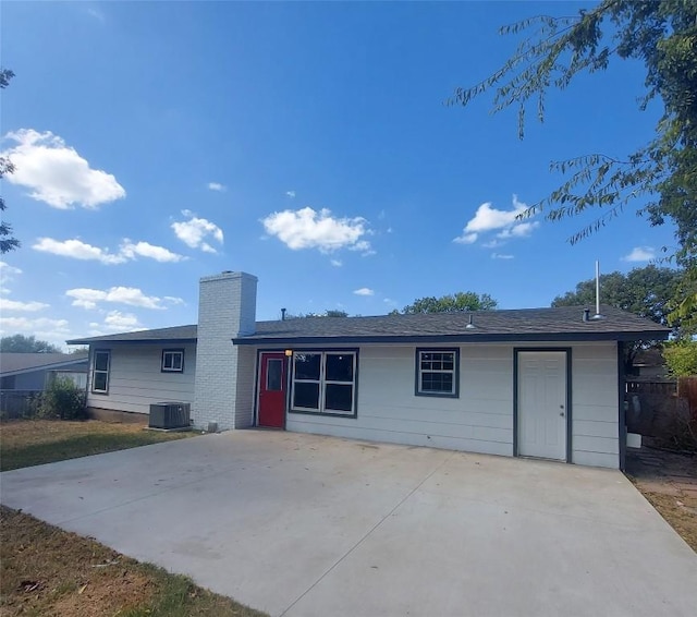 ranch-style house featuring central air condition unit, a patio, and a chimney