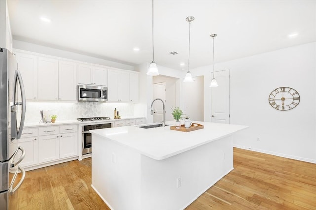 19020 Fernando Trl, Austin, TX 78738 - kitchen featuring a sink, appliances with stainless steel finishes, light wood finished floors, an island with sink, and tasteful backsplash