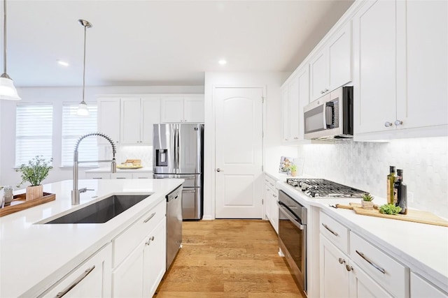 19020 Fernando Trl, Austin, TX 78738 - kitchen with stainless steel appliances, a sink, white cabinets, decorative light fixtures, and recessed lighting
