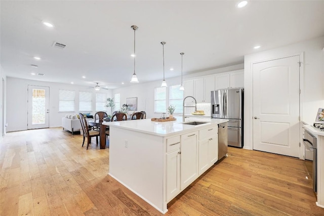 19020 Fernando Trl, Austin, TX 78738 - kitchen with a sink, appliances with stainless steel finishes, recessed lighting, light wood finished floors, and white cabinetry