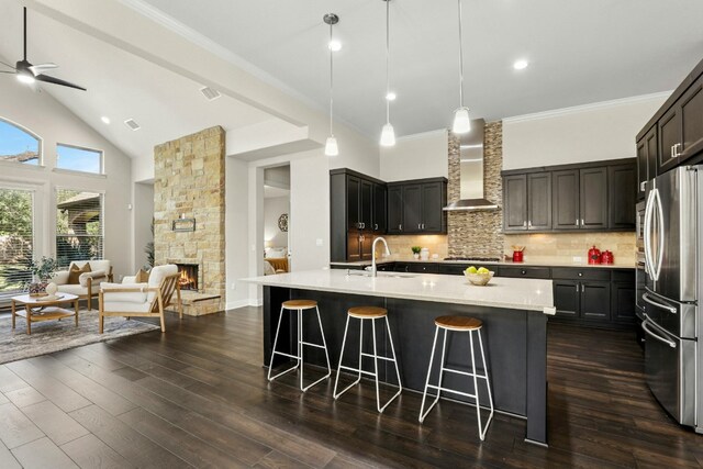 10408 Nicolet Way, Austin, TX 78717 - kitchen featuring wall chimney exhaust hood, stainless steel appliances, a sink, open floor plan, and a kitchen bar