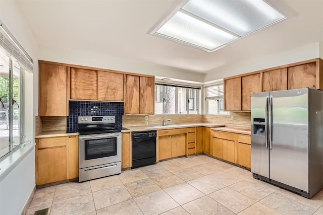 kitchen with a sink, light countertops, stainless steel appliances, backsplash, and visible vents