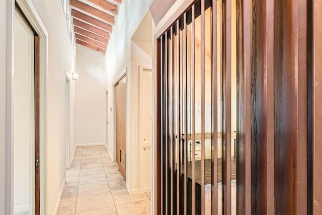 corridor featuring baseboards and light tile patterned floors