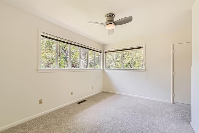 carpeted empty room featuring a ceiling fan, baseboards, and visible vents