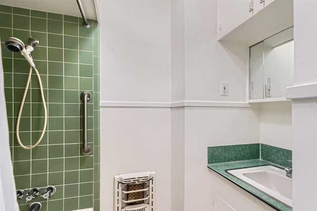 bathroom featuring heating unit and vanity