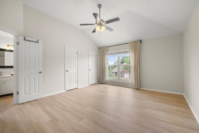 8011 Tantara Ct, Austin, TX 78729 - unfurnished bedroom with lofted ceiling, light wood-style floors, baseboards, connected bathroom, and multiple closets