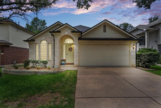 12804 Council Bluff Dr, Austin, TX 78727 - view of front facade featuring stone siding, driveway, an attached garage, and a lawn