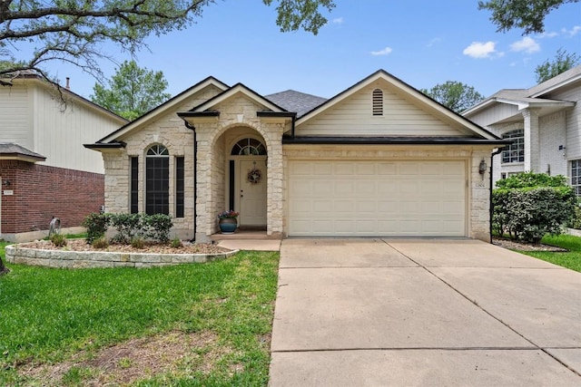 view of front of house featuring a garage, stone siding, driveway, and a front yard