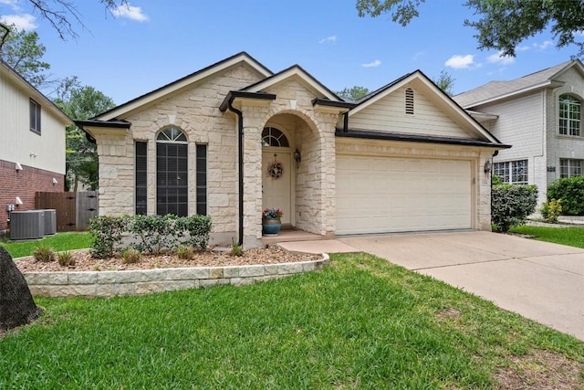 view of front of property with a front yard, cooling unit, stone siding, concrete driveway, and an attached garage