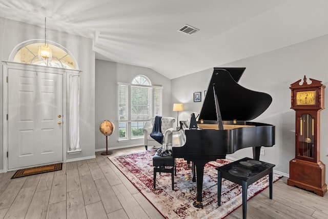 entryway featuring visible vents, baseboards, wood finished floors, and vaulted ceiling