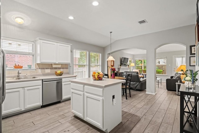 kitchen featuring visible vents, arched walkways, dishwasher, a sink, and light wood-style floors