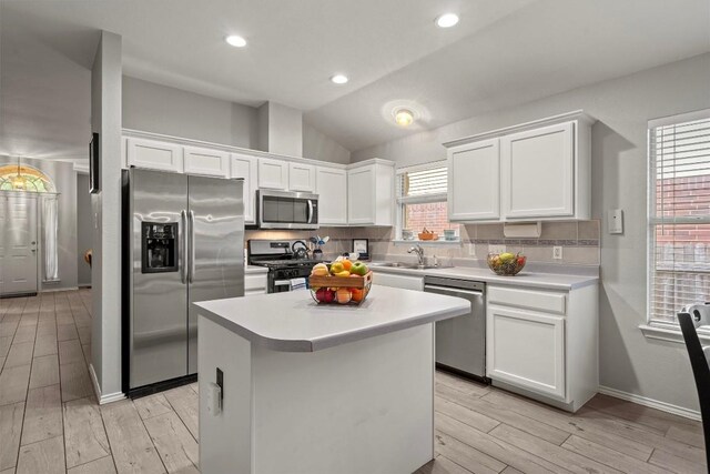 12804 Council Bluff Dr, Austin, TX 78727 - kitchen with appliances with stainless steel finishes, decorative backsplash, white cabinetry, a sink, and lofted ceiling