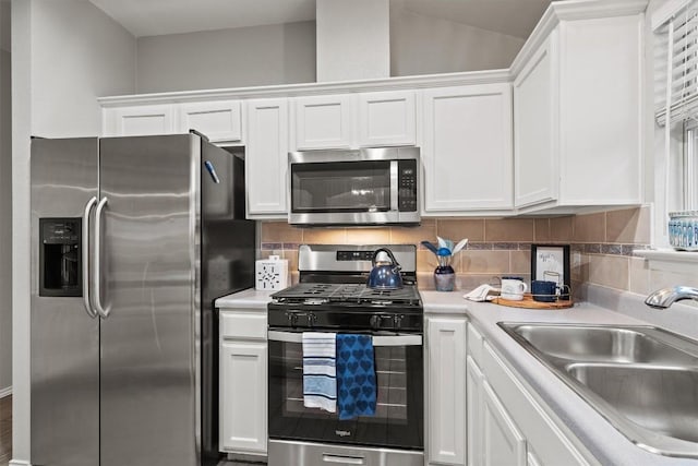 kitchen featuring a sink, appliances with stainless steel finishes, white cabinets, and light countertops