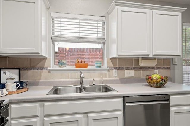 kitchen with a sink, dishwasher, light countertops, white cabinetry, and backsplash
