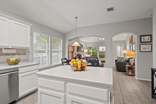 kitchen featuring arched walkways, a wealth of natural light, stainless steel dishwasher, and visible vents
