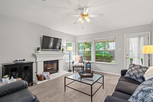 12804 Council Bluff Dr, Austin, TX 78727 - living area featuring a ceiling fan, wood finished floors, a fireplace with raised hearth, and baseboards