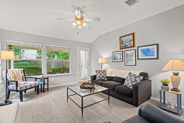 living room featuring visible vents, baseboards, ceiling fan, light wood-style flooring, and vaulted ceiling