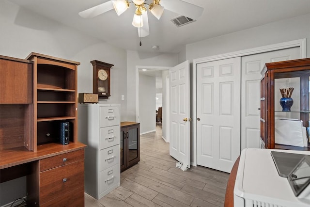 home office featuring visible vents, a ceiling fan, and light wood-type flooring