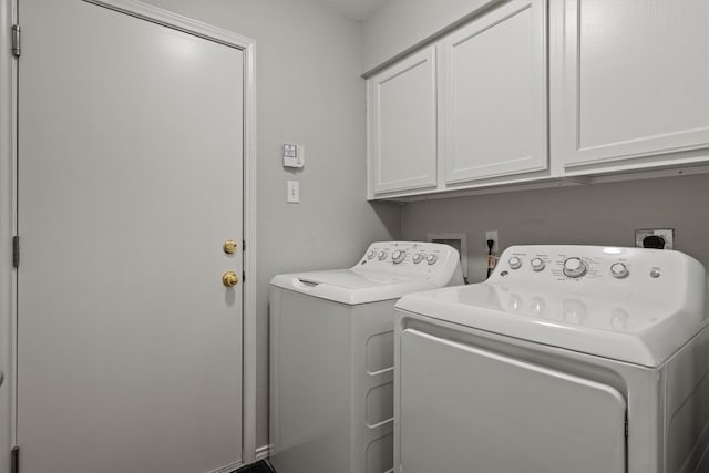 clothes washing area with cabinet space and independent washer and dryer