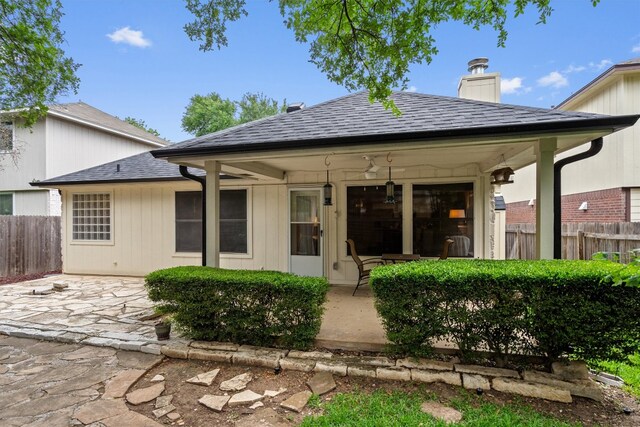 12804 Council Bluff Dr, Austin, TX 78727 - rear view of house featuring a patio, a chimney, and roof with shingles