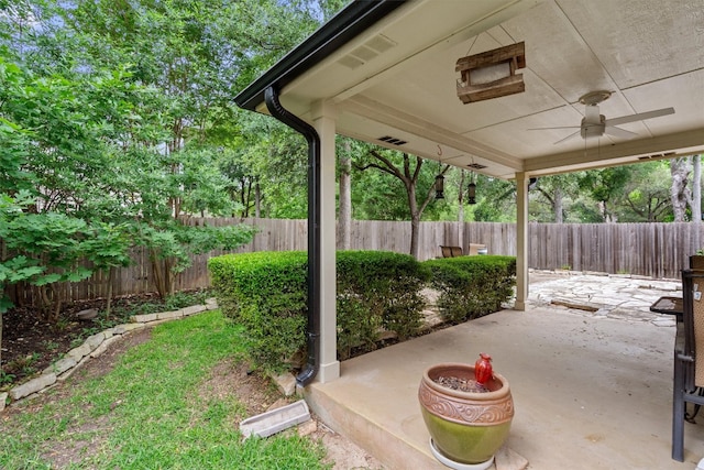 view of yard with a fenced backyard, a ceiling fan, and a patio area