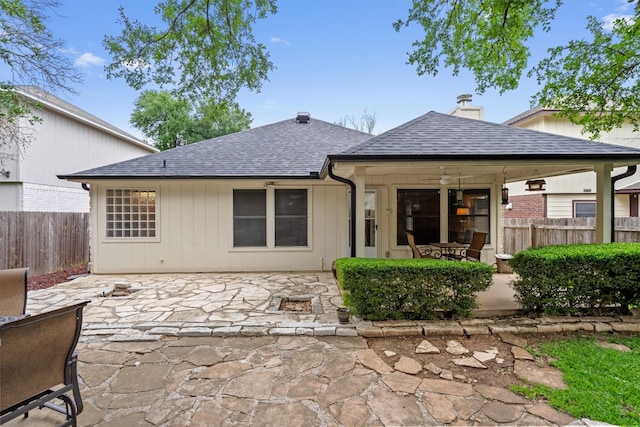 back of house with fence, a patio, and a shingled roof