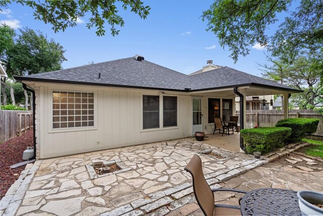 12804 Council Bluff Dr, Austin, TX 78727 - rear view of house with a shingled roof, a patio, and a fire pit