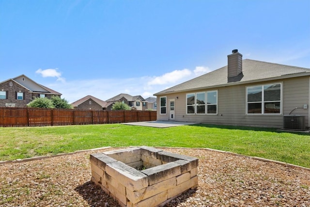 rear view of property with fence, a chimney, a patio area, and an outdoor fire pit