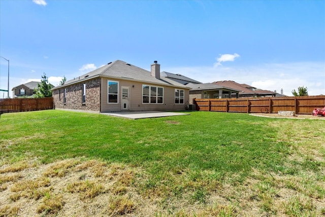 back of property with a yard, a patio, and a fenced backyard