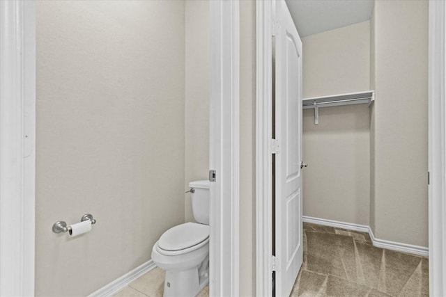 bathroom featuring toilet and baseboards