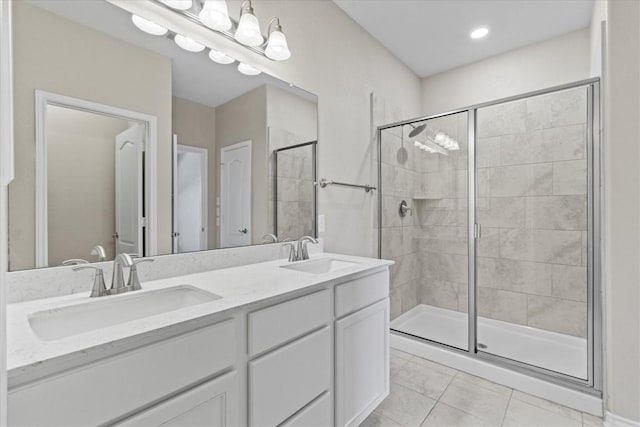 bathroom with double vanity, a sink, and a stall shower