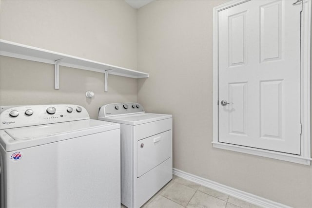laundry area with light tile patterned floors, baseboards, laundry area, and washing machine and dryer