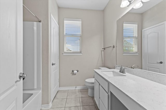 bathroom with vanity, tile patterned flooring, baseboards, and toilet
